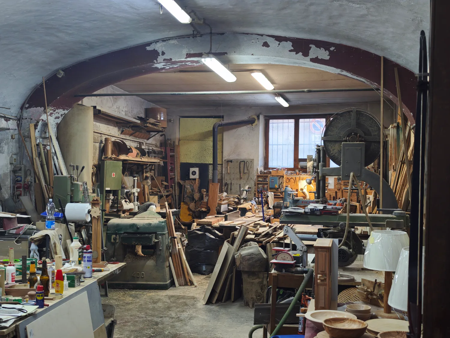 The wood shop: a vaulted workshop of saws, lathes and stacked timber